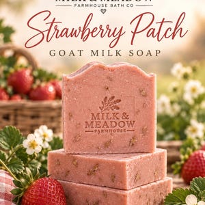 Puede incluir: Tres barras apiladas de jabón de leche de cabra rosa con aroma a fresa. La barra superior presenta el texto en relieve Milk & Meadow Farmhouse. La etiqueta superior dice Milk & Meadow Farmhouse Bath Co Strawberry Patch Goat Milk Soap.