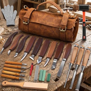 May include: A brown leather tool roll bag containing a set of wood carving knives, chisels, and gouges with wooden handles. Includes a black and orange mallet, a gray cut-resistant glove, a sharpening stone, and a leather honing strop.