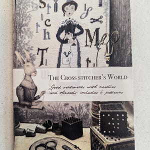 May include: A book titled "The Cross Stitcher's World" with a black and white illustration of a woman cross stitching on the cover. The text "Good sentiments with needles and threads: includes 6 patterns" is printed below the illustration.