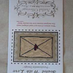 May include: A punch needle design pattern for a heart-shaped envelope with the text "Sealed With Love" and "Punchneedle Design".