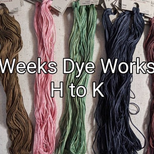 Può includere: Cinque matasse di filo per ricamo Weeks Dye Works in tonalità marrone, rosa, verde, blu scuro e bordeaux. Le matasse sono etichettate con il nome del marchio e i numeri dei colori. Il testo "Weeks Dye Works H to K" è stampato sotto le matasse.