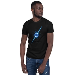 Könnte beinhalten: Ein schwarzes T-Shirt mit kurzen Ärmeln und einer Grafik eines leuchtend blauen Neutronensterns mit Magnetfeldlinien und einem hellen Lichtstrahl. Der Text "NEUTRON STAR" ist in weißen Großbuchstaben unter der Grafik gedruckt.