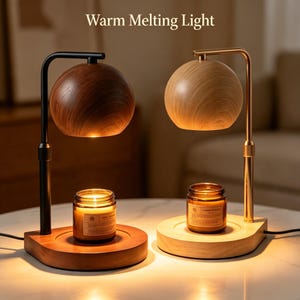 Op de afbeelding: Twee kaarsverwarmerlampen met de tekst Warm Melting Light. De ene lamp heeft een donkere houten afwerking met een zwarte metalen standaard, de andere een lichte houten afwerking met een gouden metalen standaard. Elke lamp heeft een bolvormige kap.