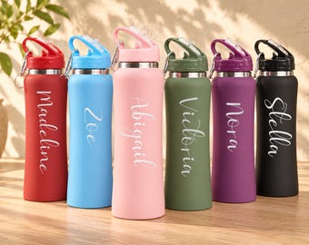 May include: Six matte-finish water bottles in red, light blue, pink, olive green, purple, and black. Each bottle features a silver-tone metal rim, a matching plastic lid with a carry loop, and a white script name: Madeline, Zoe, Abigail, Victoria, Nora, and Stella.