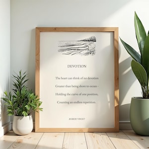 May include: A framed wall art print featuring a black and white line drawing of an ocean shoreline above the poem Devotion by Robert Frost. The text reads: The heart can think of no devotion, Greater than being shore to ocean, Holding the curve of one position, Counting an endless repetition.