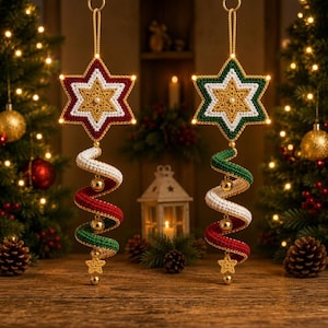 May include: Two hanging star ornaments crafted from crocheted yarn. The left star features red, white, and gold layers, while the right star features green, white, and gold. Each has a spiraling tail of red, white, and green yarn with small gold bells.