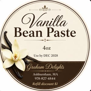 May include: A round product label for Vanilla Bean Paste featuring a cream background with dark brown text. The label displays a white vanilla flower and dark brown vanilla beans. Text includes 4oz, Use by DEC 2028, Graham Delights, Ashburnham, MA, 978-827-4844, and Refill discount $1.