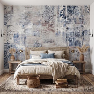May include: A bedroom featuring a large bed with a wooden frame, layered with beige and blue bedding. The wall behind the bed displays a mural with a distressed brick texture in shades of white, gray, and deep blue, accented by two wall sconces.