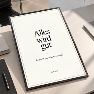 May include: A rectangular framed wall art piece featuring a white background with black text. The text reads Alles wird gut, followed by the English translation Everything will be alright, and the word GERMAN at the bottom with small dashes.