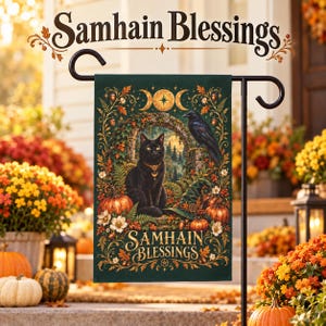 Puede incluir: Una bandera de jardín rectangular con un gato negro, un cuervo y un sombrero de bruja rodeados de follaje otoñal, calabazas y un símbolo de triple luna. El texto Samhain Blessings está impreso en oro en la parte superior e inferior.