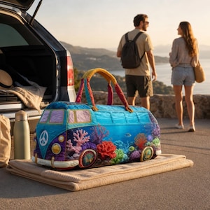May include: A duffel bag shaped like a vintage van, featuring a vibrant underwater coral reef print with colorful fish, a peace sign on the front, and yellow handles. The bag is resting on a folded beige blanket near a car trunk.