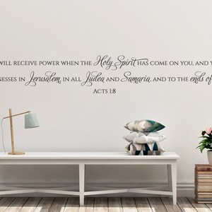 May include: A white wall with a black vinyl decal of a Bible verse from Acts 1:8. The verse reads "But you will receive power when the Holy Spirit has come on you, and you will be my witnesses in Jerusalem, in all Judea and Samaria, and to the ends of the earth. Acts 1:8".