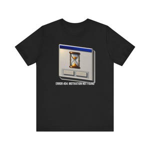 Könnte beinhalten: Ein schwarzes Kurzarm-T-Shirt mit einer Grafik eines alten Computer-Dialogfensters mit blauer Titelleiste, einem zentralen Sanduhr-Symbol und zwei grauen Schaltflächen. Unter der Grafik steht der Text ERROR 404: MOTIVATION NOT FOUND.