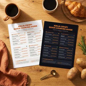 May include: Two Ninja Crispi Quick Cooking Guide sheets, one white and one black, featuring cooking temperatures and times for various foods. The guides are arranged on a wooden surface alongside two mugs of coffee, a croissant, and potatoes.