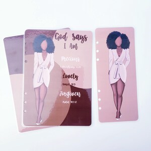 May include: Planner inserts with illustrations of a woman in a white dress. The inserts have text that reads "God says I Am Precious, Lovely, Forgiven" with Bible verses. The inserts are in shades of pink, brown, and white.