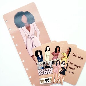May include: A planner insert set featuring illustrations of women in various outfits. The set includes a large bookmark with a woman in a pink dress, several cards with illustrations, and decorative tape. The text "God says I am unique psalm 139:13" is visible.