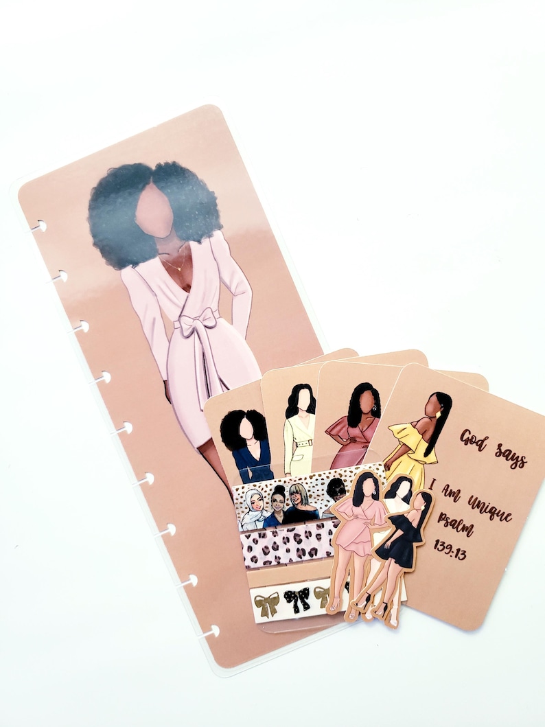 May include: A planner insert set featuring illustrations of women in various outfits. The set includes a large bookmark with a woman in a pink dress, several cards with illustrations, and decorative tape. The text "God says I am unique psalm 139:13" is visible.