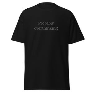 Peut inclure: Un t-shirt noir à manches courtes avec le texte blanc "Probably overthinking" imprimé dans une police simple et épurée au centre de la poitrine. Le vêtement présente un col rond classique et une coupe standard et décontractée.