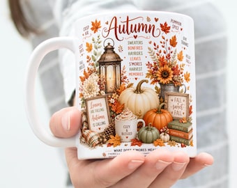 May include: A white ceramic mug featuring an autumn-themed illustration with a lantern, pumpkins, a smaller mug labeled 'Cozy & Blessed', and signs reading 'Leaves are falling autumn is calling' and 'Fall sweet fall' with various seasonal text.