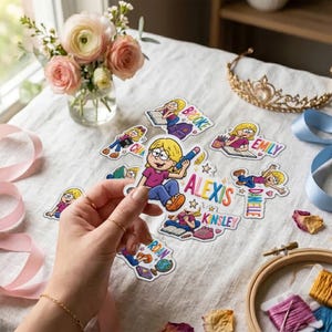 Op de afbeelding: Een verzameling gestanste stickers met cartoonillustraties van blonde personages met verschillende namen, waaronder Brooke, Emily, Alexis, Kinsley, Danielle en Jordan. De stickers tonen personages die lezen, schrijven en schoolspullen gebruiken.