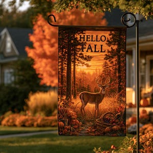 May include: A rectangular garden flag hanging from a black metal stand, featuring a printed scene of a deer in a forest at sunset with the text HELLO FALL. The image includes orange autumn foliage, pumpkins, and a basket of fruit on the ground.