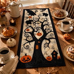 May include: A rectangular quilted table runner featuring a black tree silhouette against a cream background. The design includes orange jack-o'-lanterns, small bats, and a black house silhouette. The runner has a black border and intricate stitching.
