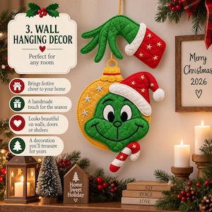 May include: A quilted wall hanging decor featuring a green hand holding a yellow ornament with a green face wearing a red Santa hat and a candy cane. The text reads 3. WALL HANGING DECOR, Merry Christmas 2026, Home Sweet Holiday, JOY, PEACE, LOVE.
