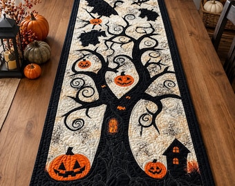 May include: A rectangular quilted table runner featuring a black tree silhouette against a cream background. The design includes orange jack-o'-lanterns, black bats, and a small black house. The border is solid black with intricate stitching throughout.