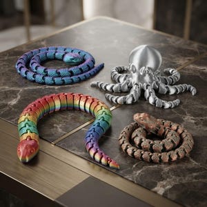 Könnte beinhalten: Eine Sammlung von vier beweglichen Tierfiguren, bestehend aus einer blau-violett schillernden Schlange, einer regenbogenfarbenen Schlange, einem metallisch silbernen Oktopus und einer kupferfarbenen Schlange, alle mit segmentierten Körpern.