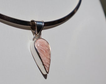 May include: A silver pendant necklace with a teardrop-shaped pink stone.