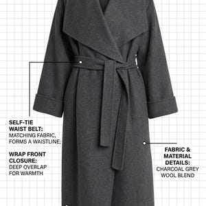 May include: An oversized charcoal grey wool blend wrap coat featuring a wide shawl collar, a self-tie waist belt, a deep wrap front closure, and wide turn-up cuffs. The image includes technical text labels describing the garment construction.