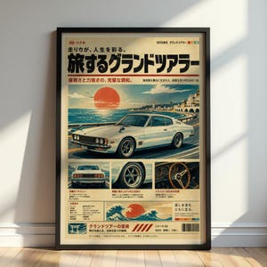 May include: A framed vintage-style poster featuring a white sports car driving along a coastal road at sunset. The design includes Japanese text, a large red sun, a rear view of the car, a close-up of a wheel, and a wooden steering wheel interior.