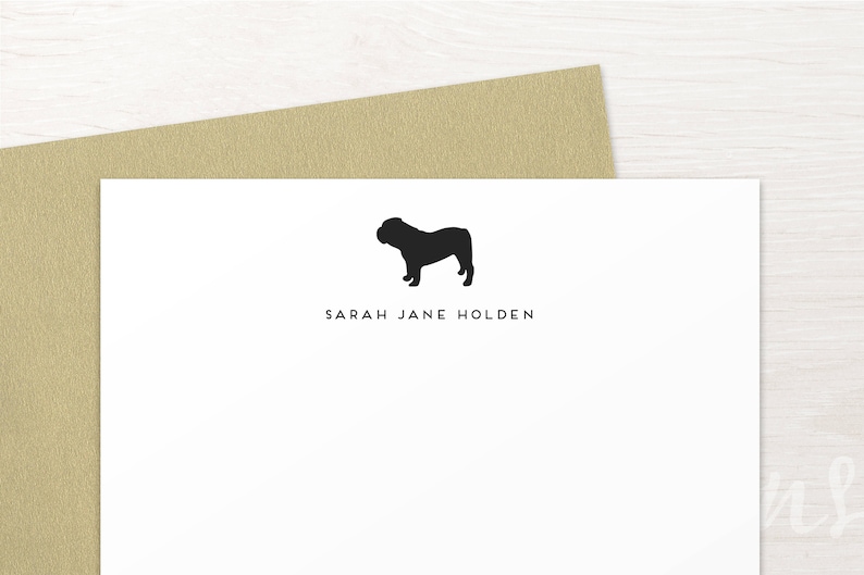 May include: A white card with a black silhouette of a bulldog and the text "SARAH JANE HOLDEN" printed in black.