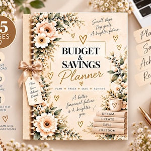 Peut inclure: Un planificateur de budget et d'épargne à reliure spirale avec un fond crème, des illustrations florales et des cœurs dorés. La couverture porte le texte Budget & Savings Planner, Small steps Big goals A brighter future et Dream Create Save Freedom.