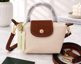 Bolso bandolera mini Longchamp, de nailon blanco, con correa para el hombro desmontable.