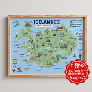 May include: A framed illustrated map of Iceland titled Teo's Travel, featuring a light blue background and green landmass. The map displays various landmarks, animals, and food items with labels, plus a red circular badge in the corner with white text.