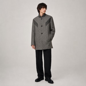 May include: A grey herringbone patterned coat with a high collar, three front buttons, and dark grey chevron-shaped panels across the chest. The coat is paired with plain black trousers and black leather shoes, creating a structured look.