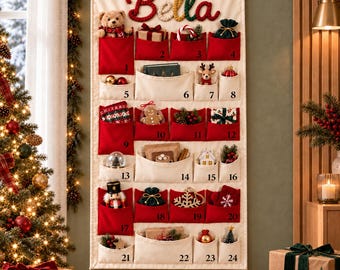 May include: A cream-colored fabric advent calendar hanging on a wall, featuring the name Bella in red, yellow, and green yarn. It has twenty-four numbered pockets in red and cream, filled with small holiday ornaments, toys, and gifts.