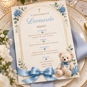 May include: A rectangular baptism menu card featuring a gold arched frame, blue floral accents, and a central illustration of a teddy bear with a blue satin ribbon. The text reads IL BATTESIMO DI Leonardo, MENÙ, ANTIPASTI, PRIMO, SECONDO, and DOLCE.