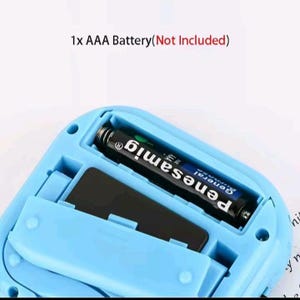 May include: A light blue plastic device with an open battery compartment containing one black AAA battery. The text 1x AAA Battery(Not Included) is printed above the device. The compartment features a spring contact and a hinged cover.