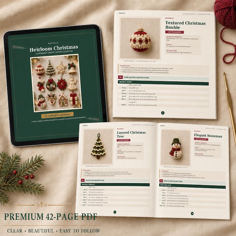 May include: A digital tablet and an open printed book displaying a crochet pattern collection titled Heirloom Christmas. The pages feature instructions and photos of handmade ornaments including a bauble, a tree, and a snowman.