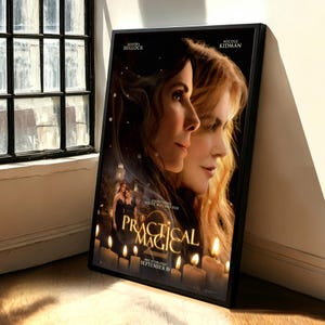 May include: A framed movie poster for Practical Magic 2 featuring portraits of Sandra Bullock and Nicole Kidman. The poster includes the title in gold lettering, the text Everything You've Witched For, and the release date September 10.