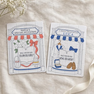 May include: Two rectangular jigsaw puzzles featuring illustrated storefronts. The left puzzle reads Sofia's Special Invitation and Will You Be Our Flower Girl? with a basket and cake. The right reads A Special Invitation for Luca and Will You Be Our Ring Bearer? with a suit and shoes.