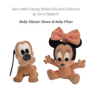 Pode incluir: Duas figuras flocadas da coleção Disney Babies dos anos 80 da Arco Mattel. Uma é um Pluto bebé castanho-claro com orelhas pretas e olhos brancos. A outra é uma Minnie Mouse bebé com um laço cor de pêssego, orelhas pretas e olhos brancos. Texto: Rare 1980s Disney Babies Flocked Collection by Arco (Mattel) Baby Minnie Mouse & baby Pluto.