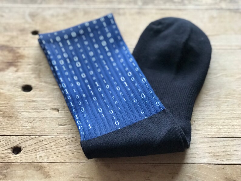 K&ouml;nnte beinhalten: Ein Paar blaue Socken mit einem wei&szlig;en Bin&auml;rcode-Muster. Die Socken haben einen schwarzen Bund.