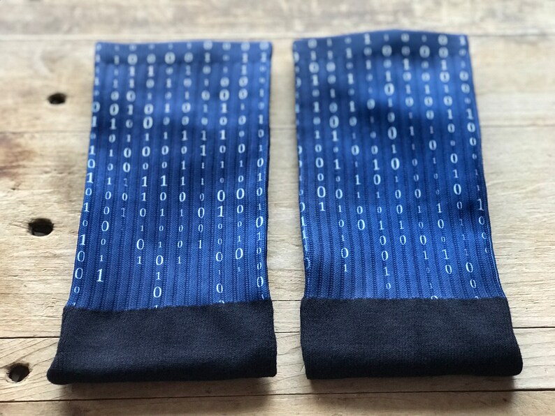 K&ouml;nnte beinhalten: Ein Paar blaue Socken mit einem wei&szlig;en Bin&auml;rcode-Muster. Die Socken haben einen schwarzen Bund.