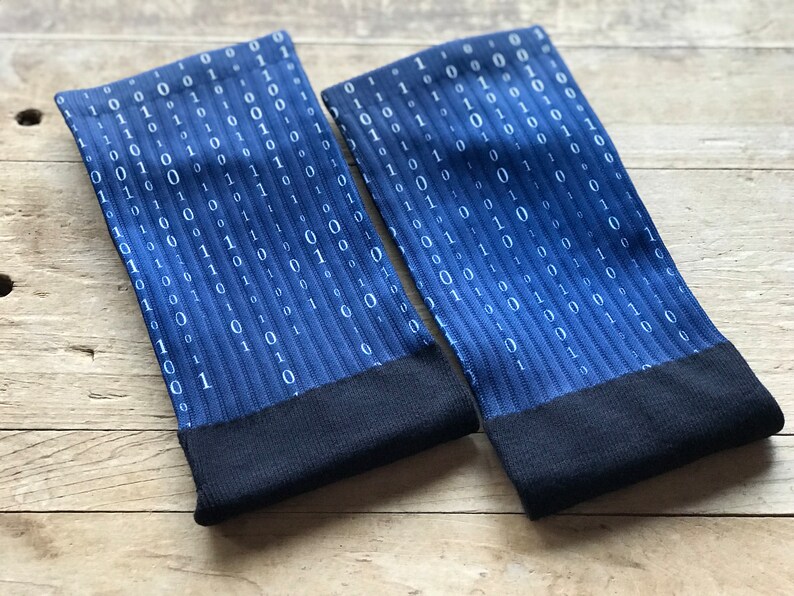 K&ouml;nnte beinhalten: Ein Paar blaue Socken mit einem wei&szlig;en Bin&auml;rcode-Muster. Die Socken haben einen schwarzen Bund.