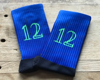 May include: A pair of blue athletic socks with a green number "12" printed on each sock.