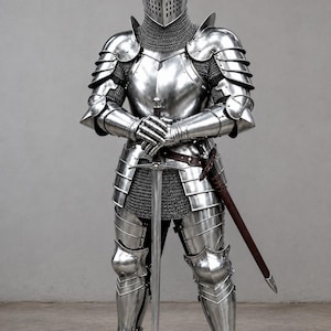 Könnte beinhalten: Eine vollständige Rüstung aus poliertem silbernem Stahlblech mit einem geschlossenen Helm mit Visier, beweglichen Schulterstücken, Handschuhen und Beinschienen. Unter den Metallplatten wird ein Kettenhemd getragen. Ein langes Stahlschwert wird aufrecht gehalten.