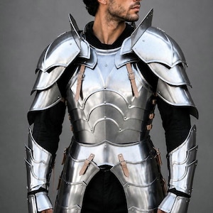 May include: A polished steel suit of armour featuring a segmented breastplate, layered pauldrons for the shoulders, and matching vambraces for the forearms. The metallic plates are secured with light tan leather straps and silver-toned metal buckles.